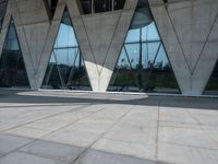 the windows in the building are large and triangular glass on either side of each other