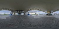 the fisheye lens on the outside of an outdoor space features many arches and a bench overlooking the city