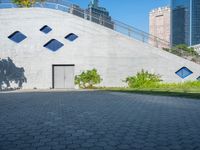 an entrance to a concrete building and an empty street is pictured in the foreground