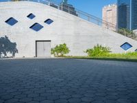 an entrance to a concrete building and an empty street is pictured in the foreground