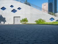 an entrance to a concrete building and an empty street is pictured in the foreground