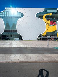 a street with many buildings and a yellow bear on it's face with a man on a phone