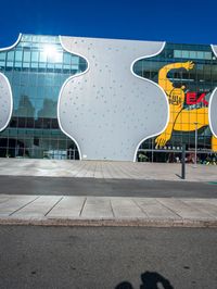 a street with many buildings and a yellow bear on it's face with a man on a phone