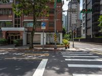 a crosswalk and street sign next to a street with buildings in the background on a clear day