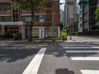 a crosswalk and street sign next to a street with buildings in the background on a clear day