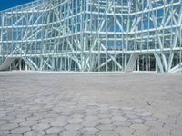 an abstract architecture photo with a large glass building behind it in the foreground and a stone floor outside