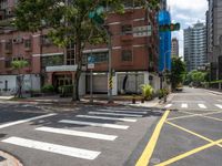 a couple of buildings with a green traffic light on the corner of the street as pedestrians ride across the road