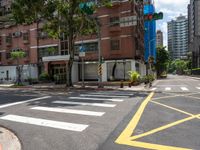 a couple of buildings with a green traffic light on the corner of the street as pedestrians ride across the road