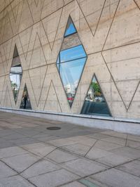 an image of the exterior of a building that has multiple triangles in it and reflecting it