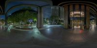 a fish eye view of a large building at night time in an upscale urban area