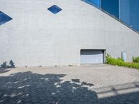 a large building with a lot of windows on each side of the door is surrounded by stone pavers