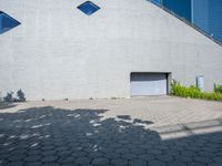 a large building with a lot of windows on each side of the door is surrounded by stone pavers