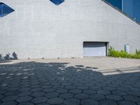 a large building with a lot of windows on each side of the door is surrounded by stone pavers