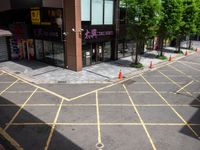 an empty lot has been marked with yellow lines and green trees in the background that are lined with cones