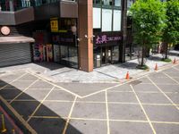 an empty lot has been marked with yellow lines and green trees in the background that are lined with cones