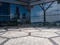 a circle made up of small circles on an outdoor area with a city reflection in the window