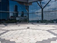 a circle made up of small circles on an outdoor area with a city reflection in the window