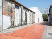 a red fire hydrant is next to a brick road corner in front of a building