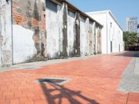 a red fire hydrant is next to a brick road corner in front of a building