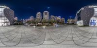 a city skyline with buildings from fisheye lens to panoramic view, as seen at night