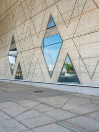 the window reflects the city and trees through the glass of this building as an image of a person riding a bicycle