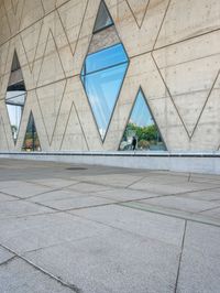 the window reflects the city and trees through the glass of this building as an image of a person riding a bicycle