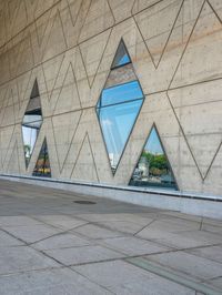 the window reflects the city and trees through the glass of this building as an image of a person riding a bicycle