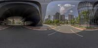 the view from two different angles at an intersection with buildings in the background, and a cloudy sky overhead