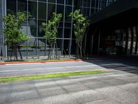 a man in an orange and black top skateboarding on the road near buildings in front of an office building