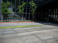 a man in an orange and black top skateboarding on the road near buildings in front of an office building