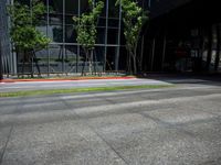 a man in an orange and black top skateboarding on the road near buildings in front of an office building