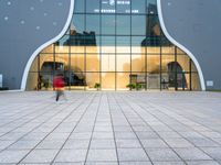 the reflection of the clock is visible in the windows of a building with an outside courtyard