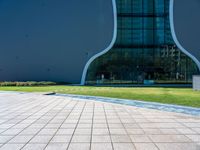 the shadow is cast on the floor near the building's exterior and grass area