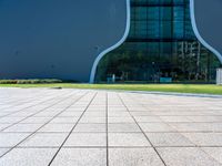 the shadow is cast on the floor near the building's exterior and grass area