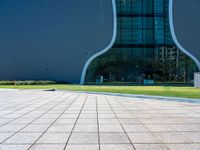 the shadow is cast on the floor near the building's exterior and grass area