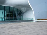 a man is sitting on a bench outside the building with his red and white frisbee