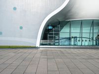 an outside building with a walkway near the side and people walking by it at night