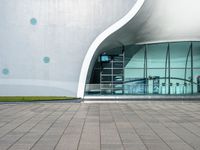 an outside building with a walkway near the side and people walking by it at night