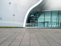 an outside building with a walkway near the side and people walking by it at night