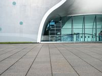 an outside building with a walkway near the side and people walking by it at night