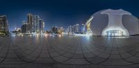 there is a sphere that is reflecting a city skyline at night time in the middle of the image