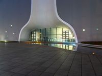 this is a large modern building with an illuminated building on the ground with buildings surrounding it