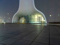 this is a large modern building with an illuminated building on the ground with buildings surrounding it