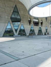 a man riding a skateboard next to an outdoor structure under a dome like structure