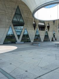 a man riding a skateboard next to an outdoor structure under a dome like structure