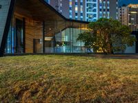 this is an image of a building at night with windows on it and a lot of grass on the lawn