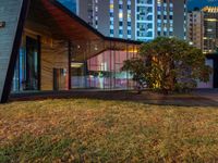 this is an image of a building at night with windows on it and a lot of grass on the lawn