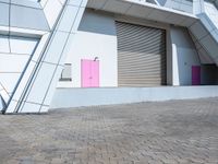 the pink door on the building is open to let people inside it by itself,