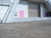 the pink door on the building is open to let people inside it by itself,