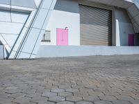 the pink door on the building is open to let people inside it by itself,